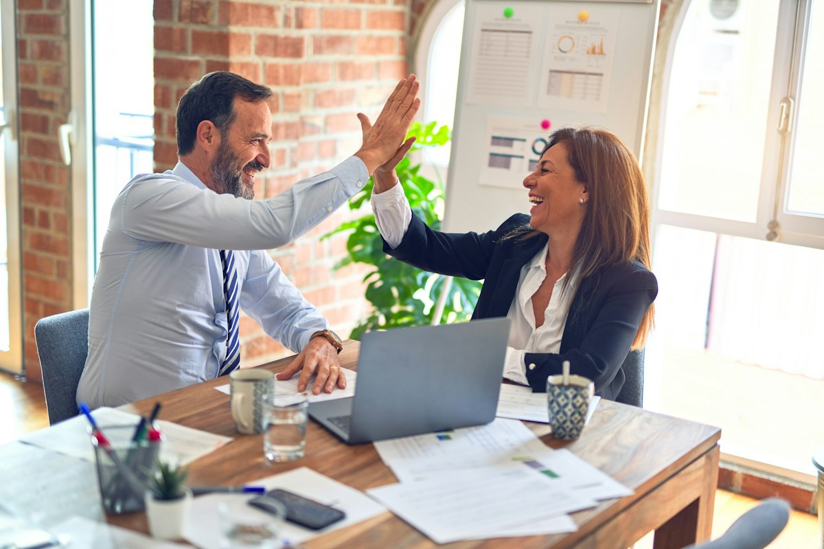 Toplantı masasında iş birliği yapan iki kişi